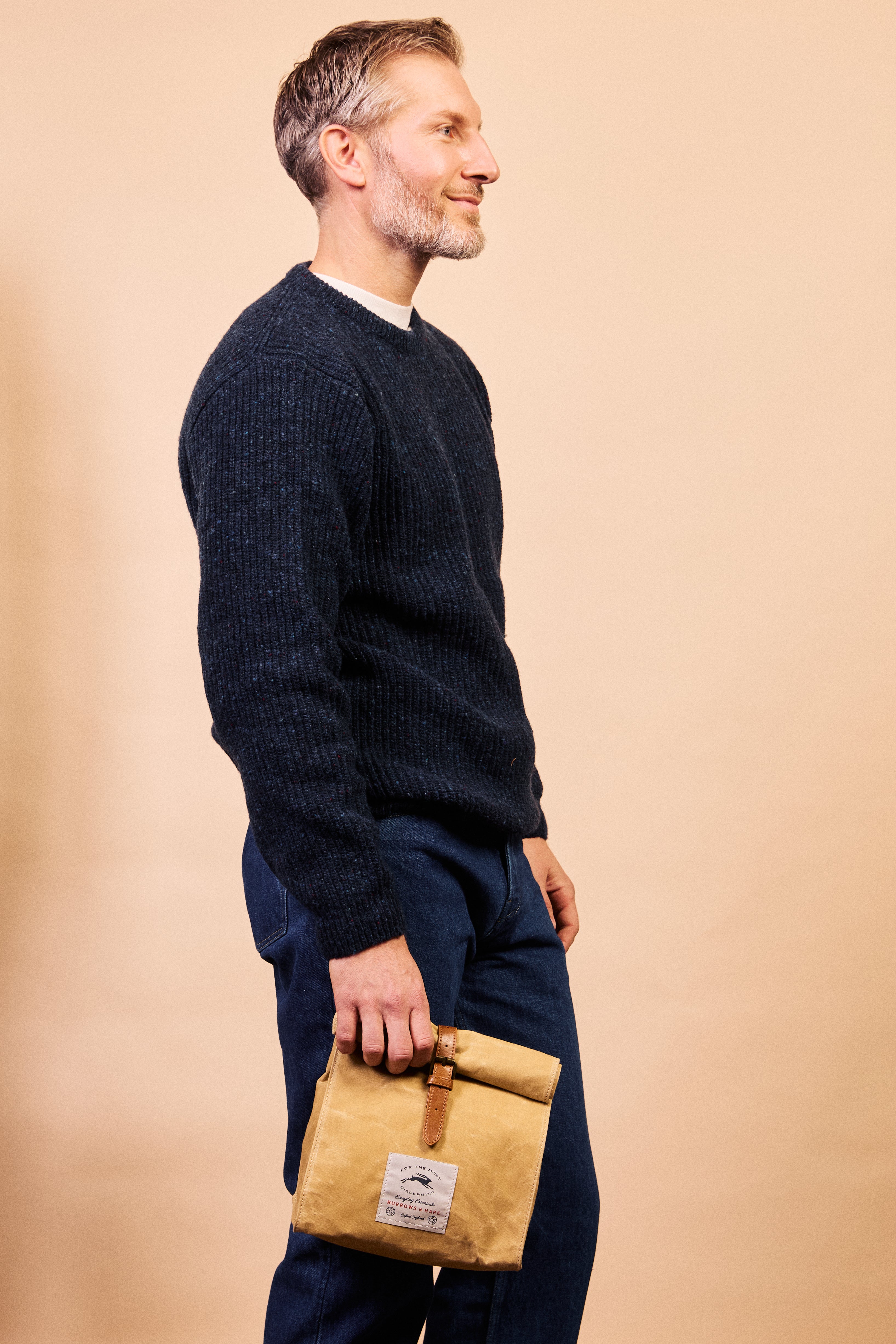 Waxed canvas thermal lunch bag held by the leather strap