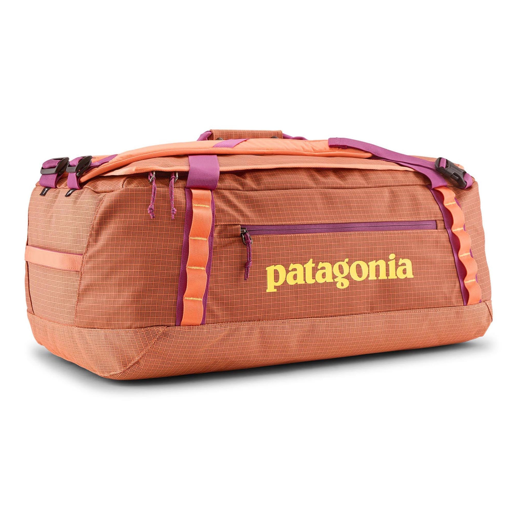 Side view of Black Hole Duffel 55L by Patagonia in Peach Sherbet, rugged and stylish.